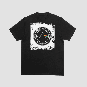 A black t-shirt featuring the Pink Floyd "Dark Side of the Moon" prism and rainbow graphic inside a circular border. The design has a distressed, white textured background. Part of the Dare To Live Vibe collection.